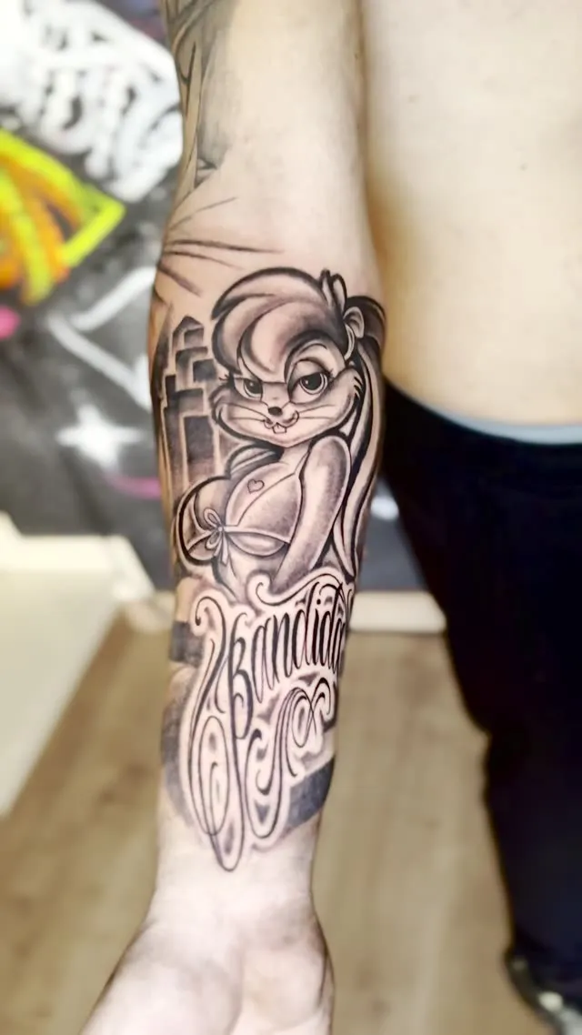 Lettering y personaje de dibujos animados en el antebrazo — tatuaje terminado — Clandestine Art Studio Marmolejo